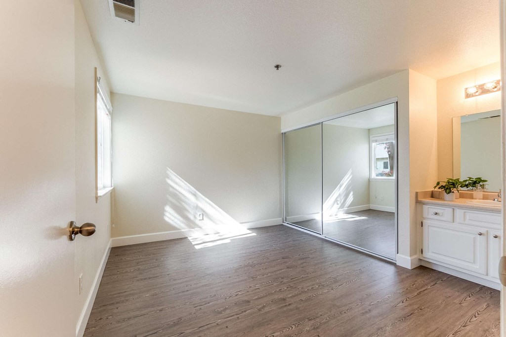 bedroom with vanity and mirrored closet doors