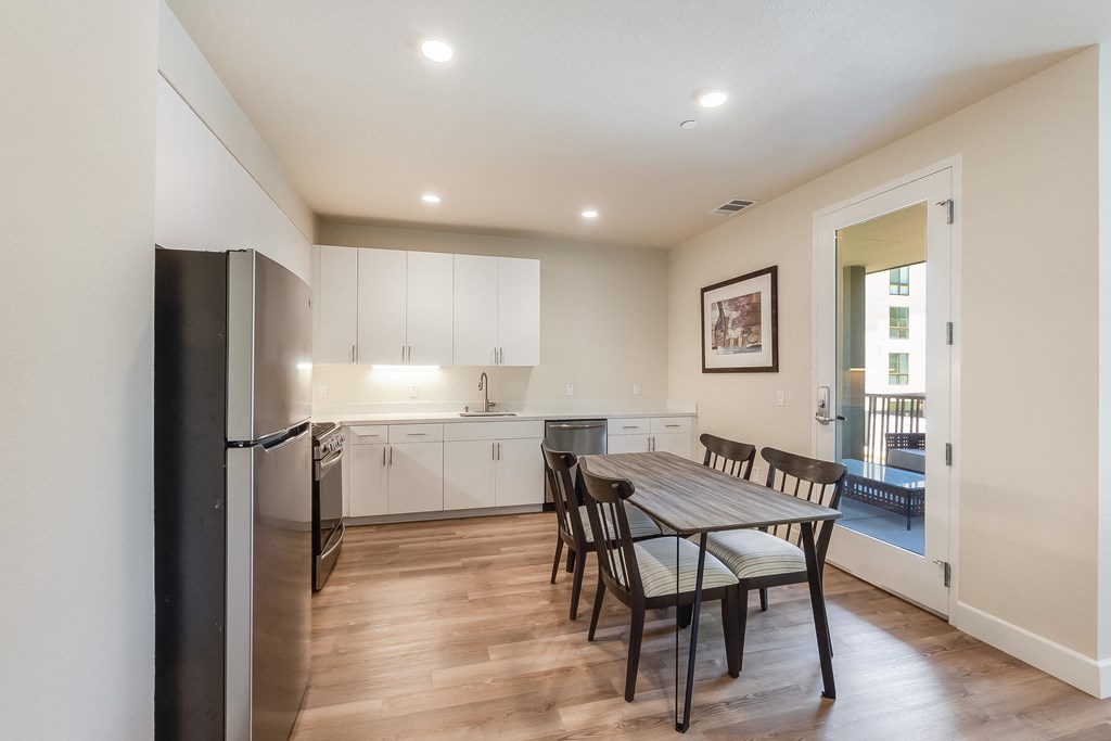 2 bedroom - kitchen with dining area and view of balcony door