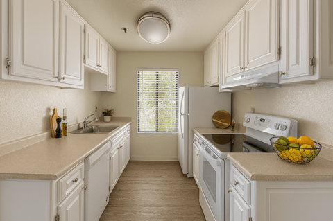 A kitchen with white cabinets and appliances.
