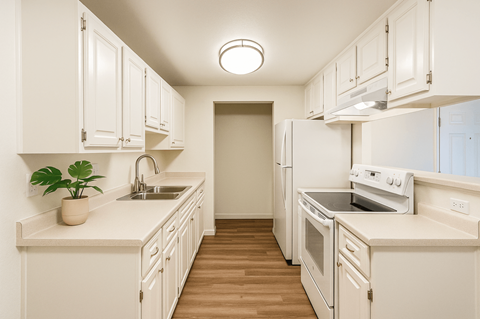 A kitchen with white cabinets and appliances.