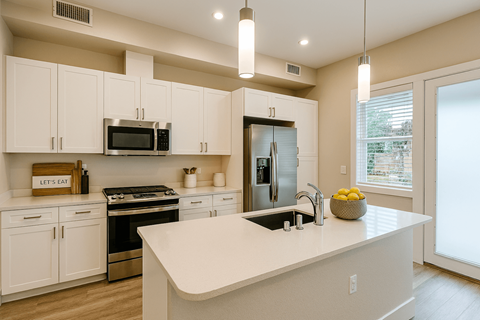A kitchen with white cabinets and a large island.