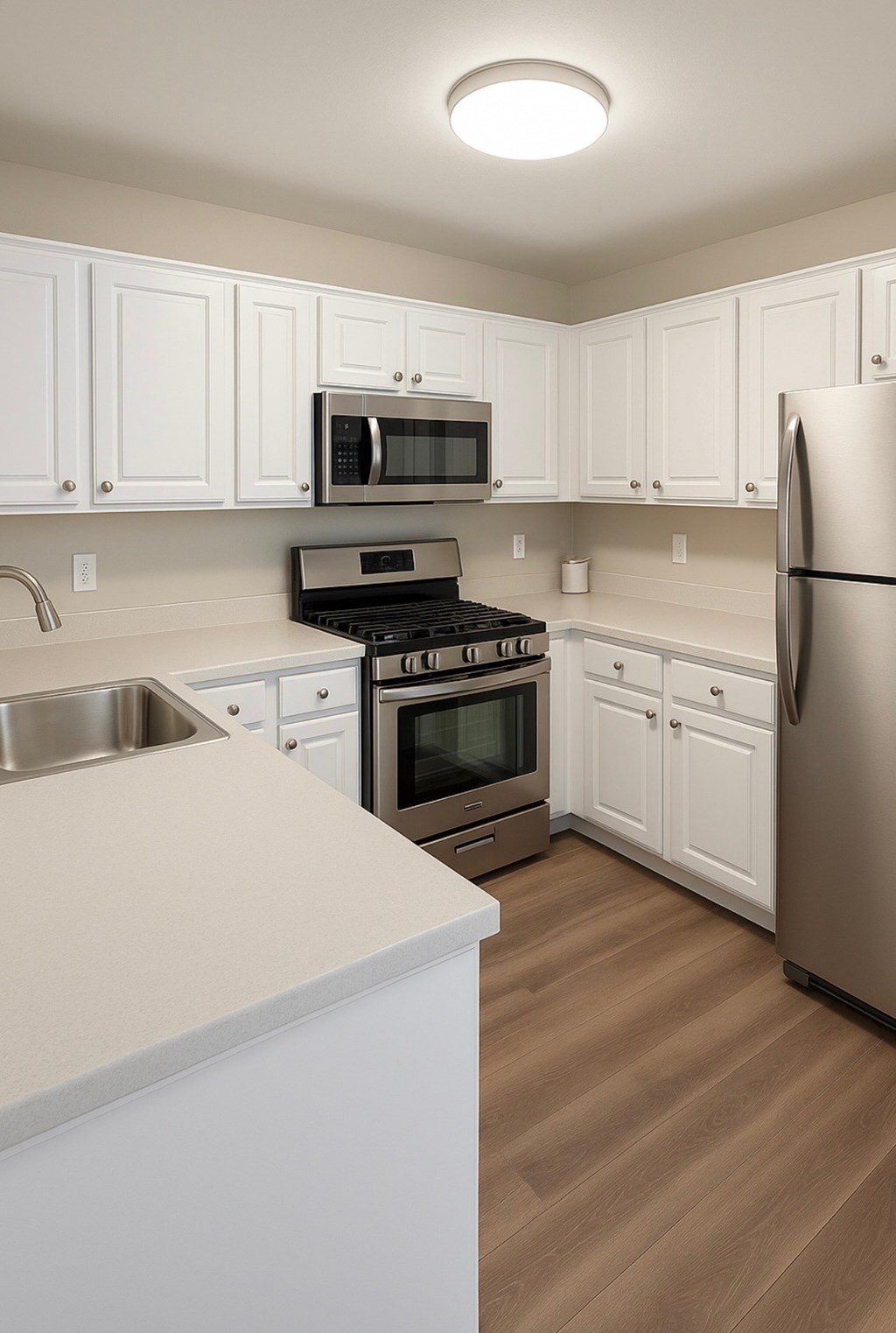 A kitchen with white cabinets and a stainless steel refrigerator.at Posada West, Novato, CA