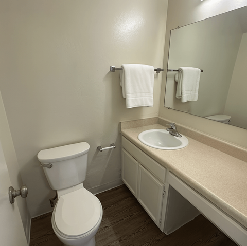 A white toilet sits next to a sink in a bathroom.at Posada East, Novato, CA