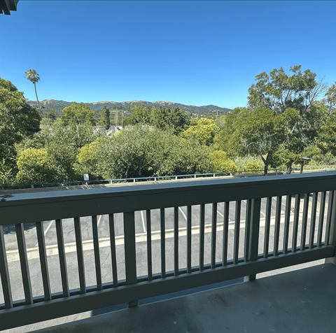 A balcony with a railing overlooking a road and trees.at Redwood Landing, Novato California