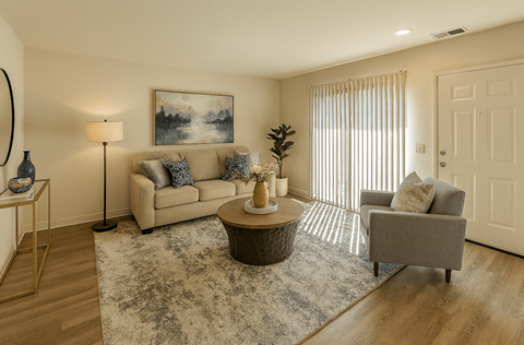 A living room with a couch, a coffee table, and a painting on the wall.