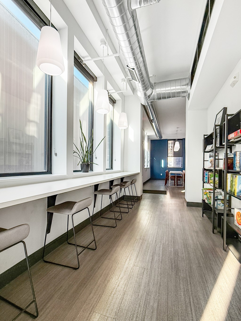 A long white table with chairs and a plant on it.