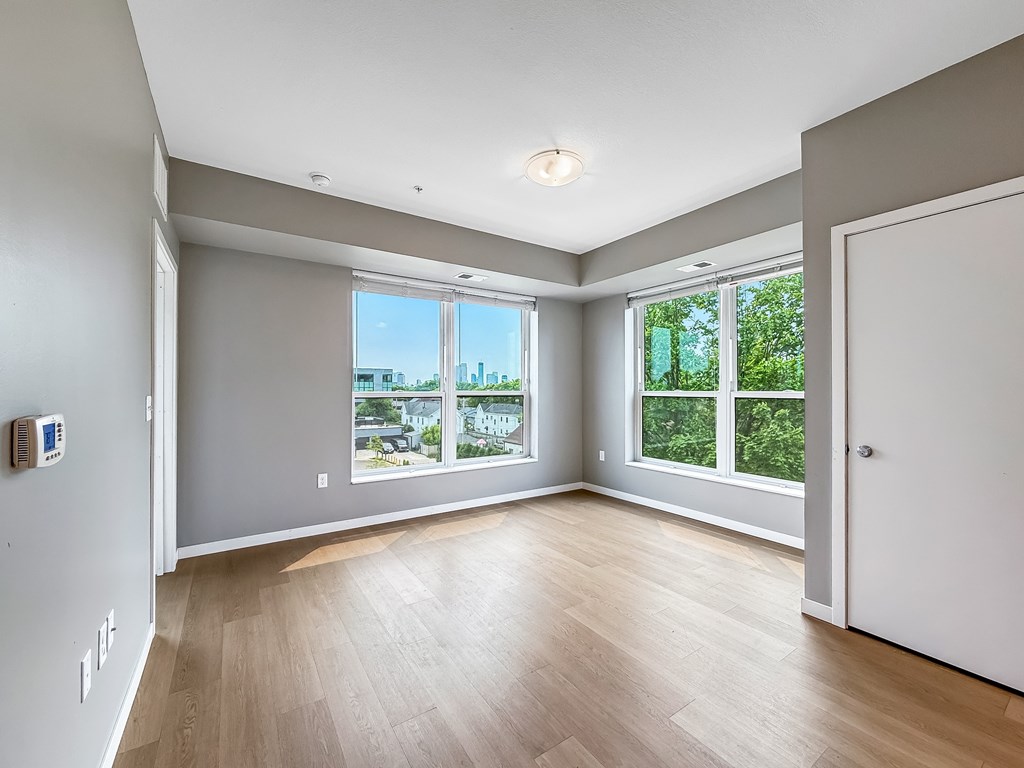 A spacious room with a view of the city through the windows.