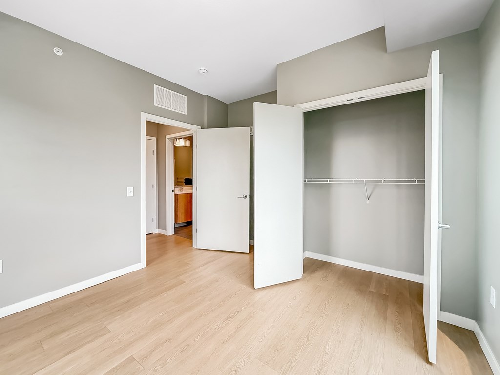 A room with a white door and a white closet.