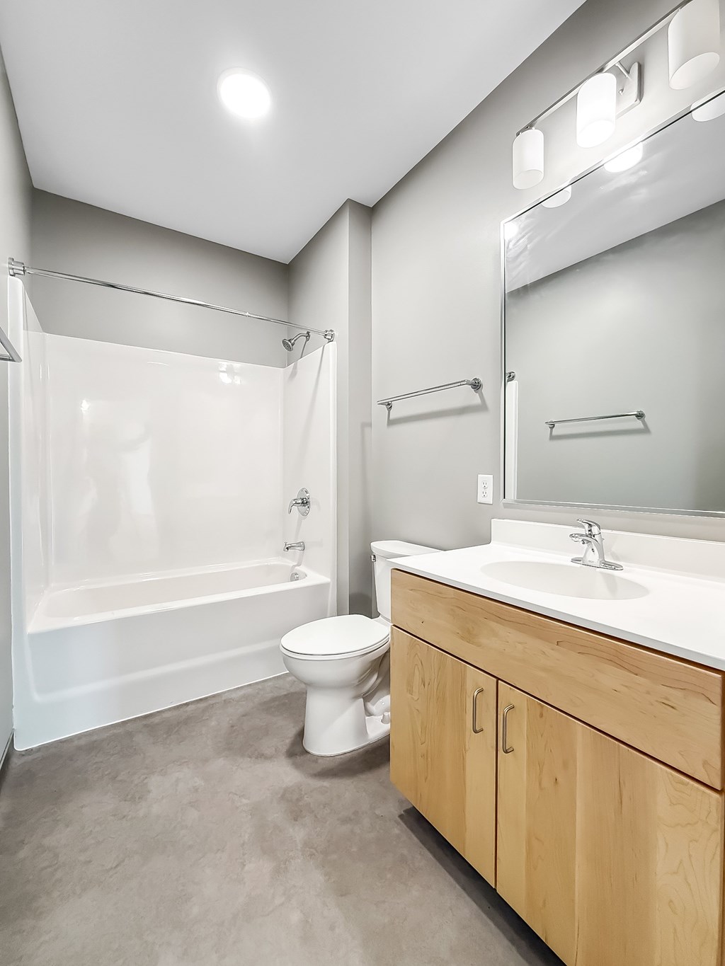 A white toilet sits next to a sink in a modern bathroom.