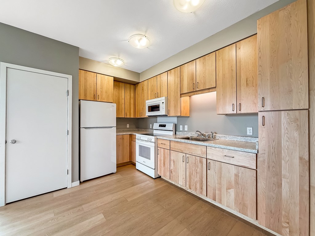 A kitchen with wooden cabinets and white appliances.