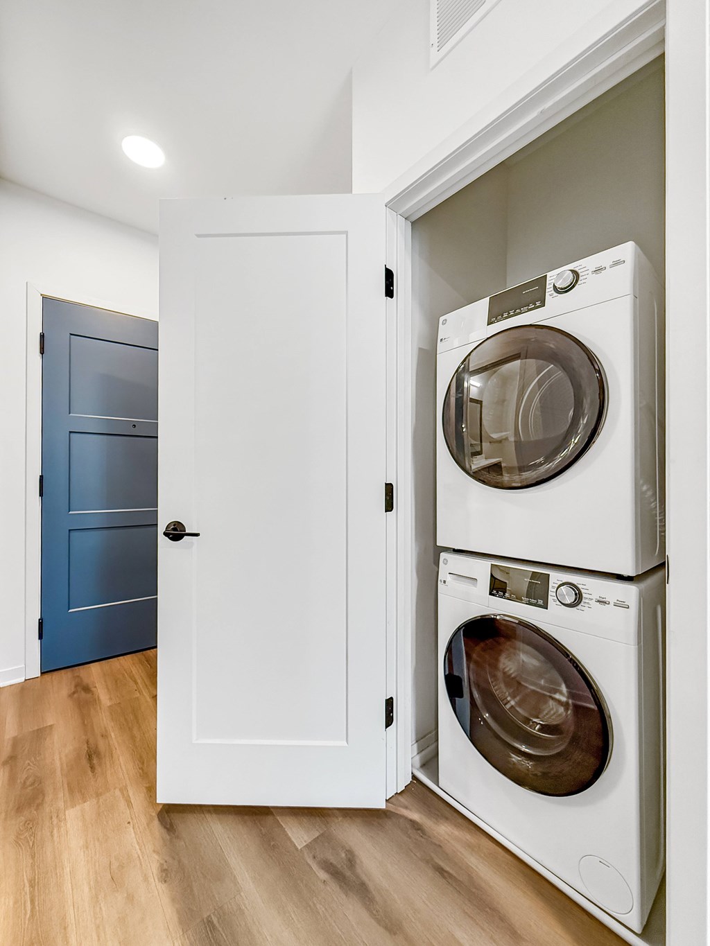 A white cabinet with two washing machines stacked on top of each other.