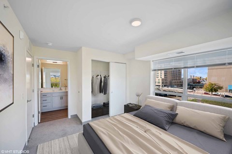 A bedroom with a large bed and a view of the city.