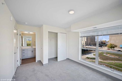 A spacious room with a view of the cityscape outside the window.