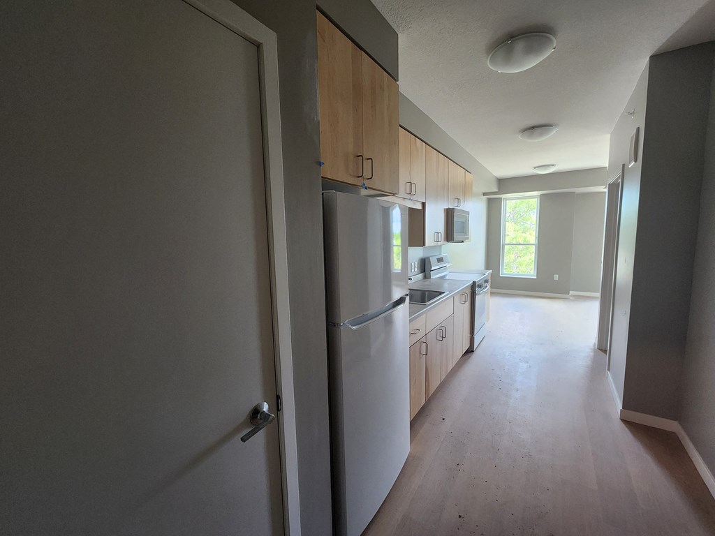 a kitchen with a white refrigerator and wooden cabinets
