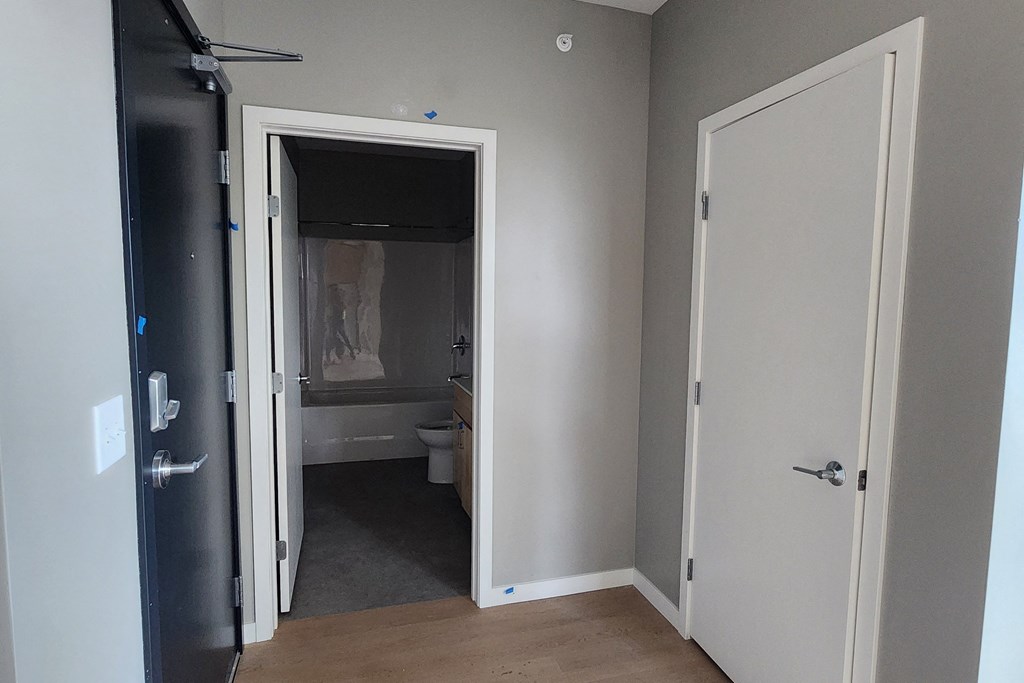 a room with a door open to a bathroom and a closet