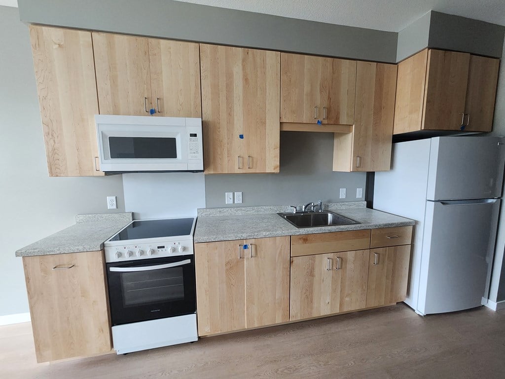a kitchen with wooden cabinets and a sink and a refrigerator