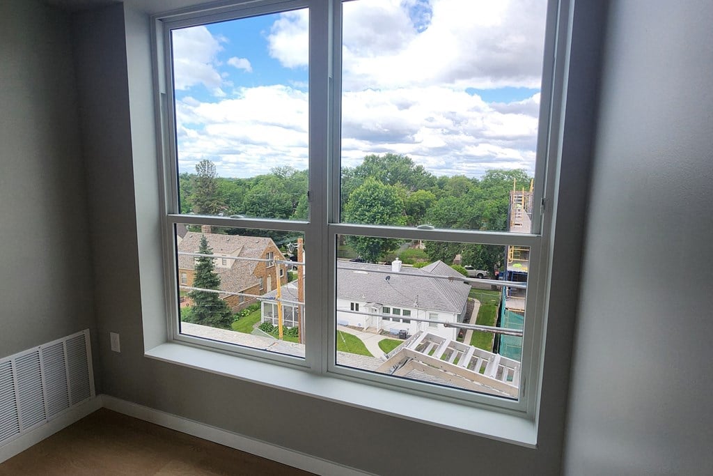 a room with a large window overlooking a neighborhood