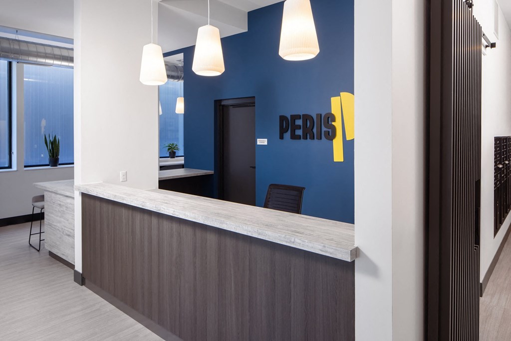 a reception area with a blue wall and a counter with a desk and chairs