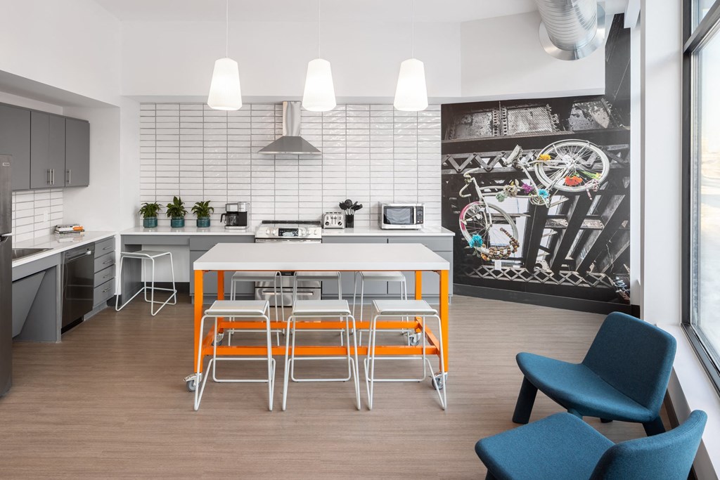 a kitchen with a white table and orange stools