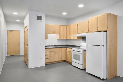 an empty kitchen with wooden cabinets and white appliances