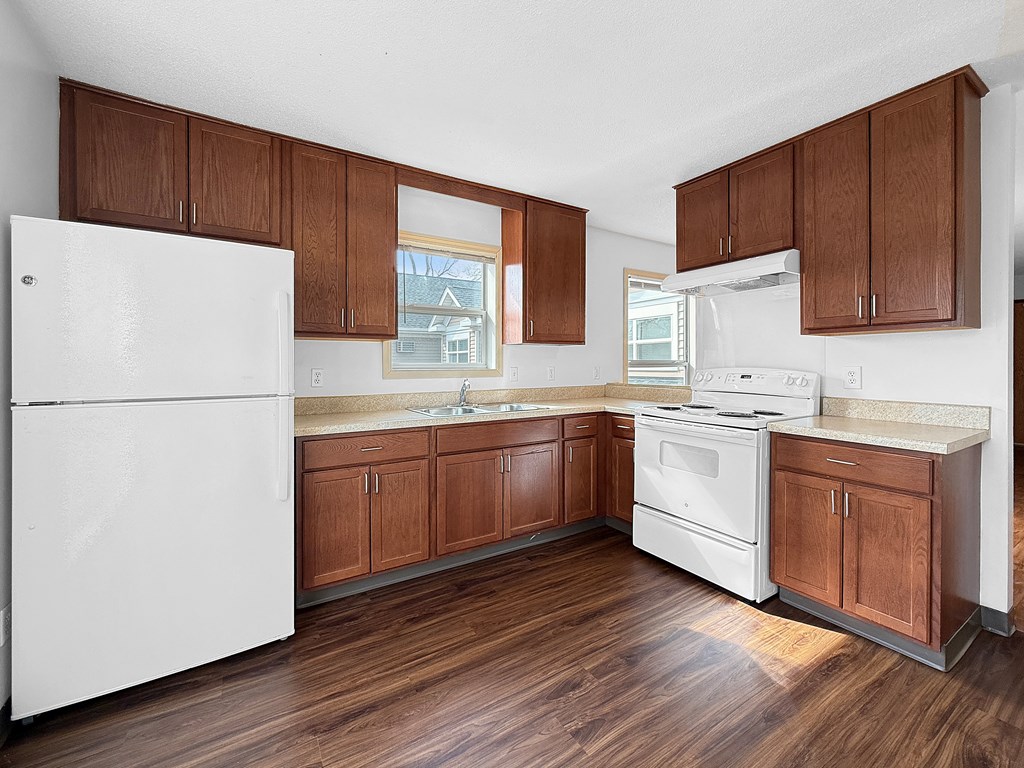 A kitchen with wooden cabinets and a white fridge.