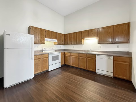 A kitchen with wooden cabinets and white appliances.