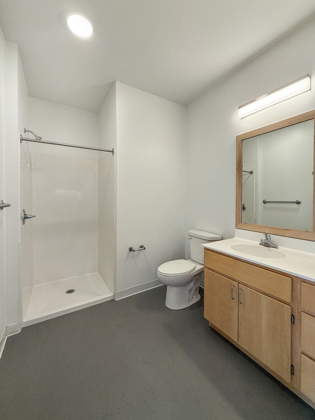 A bathroom with a toilet, sink, and shower.