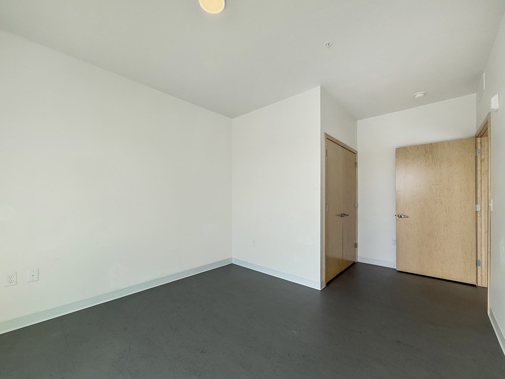 A room with a white wall and a wooden door.