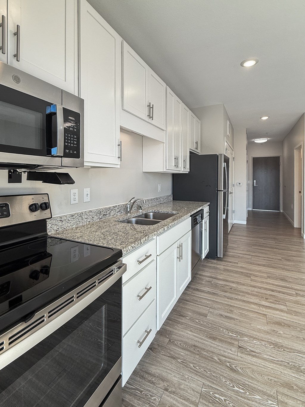 A kitchen with black appliances and white cabinets.