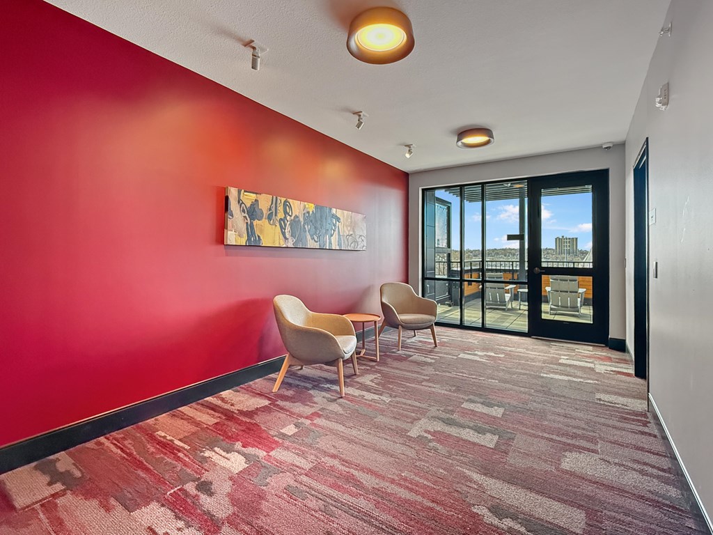 A hallway with a red wall and a painting hanging on it.