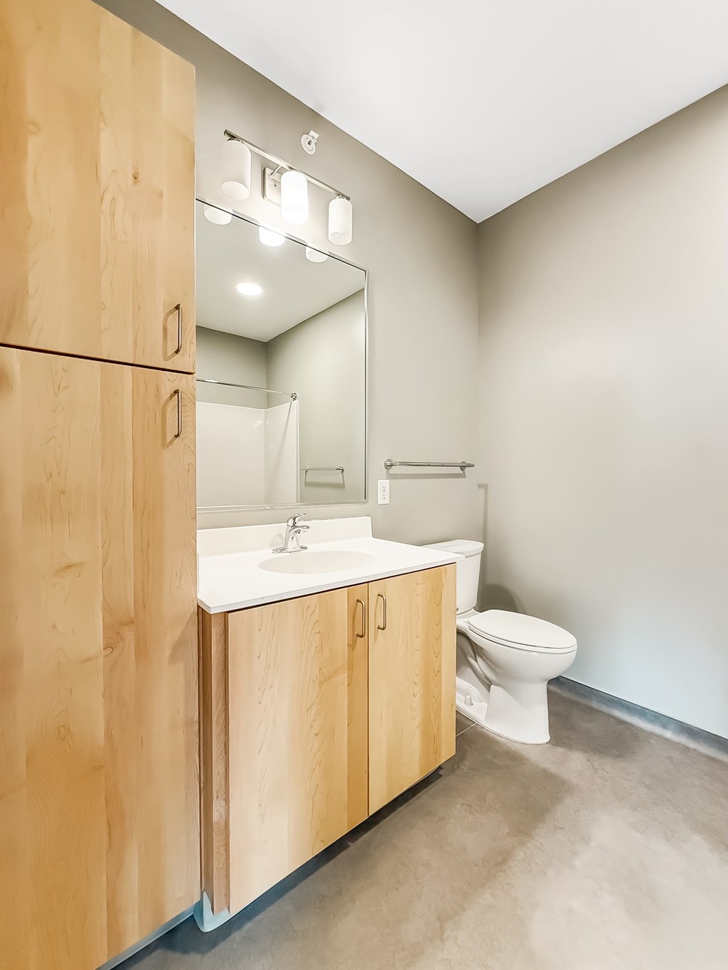 A bathroom with a toilet, sink, and medicine cabinet.