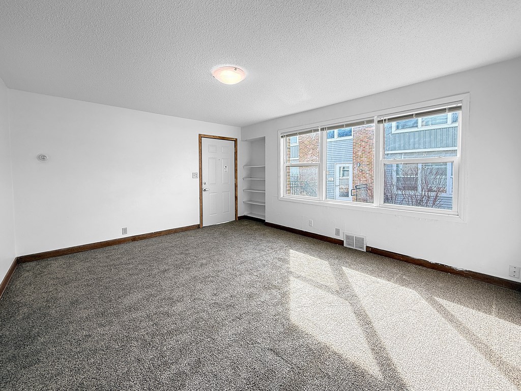 A living room with front door and large window
