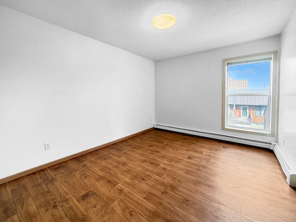 Empty room with wooden floor and a window.