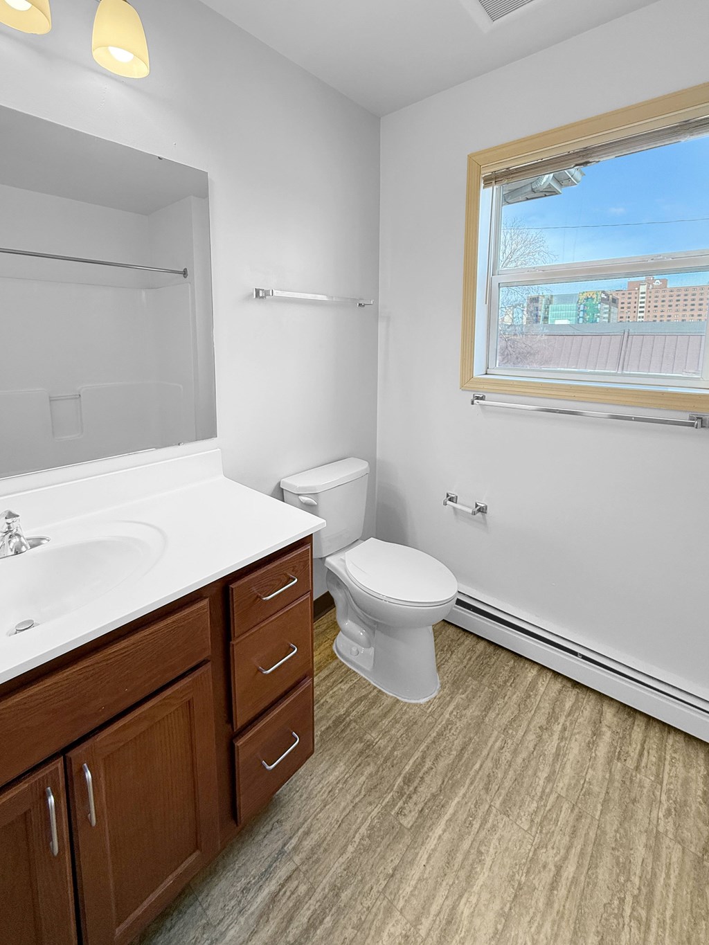 A bathroom with a toilet, sink, and mirror.