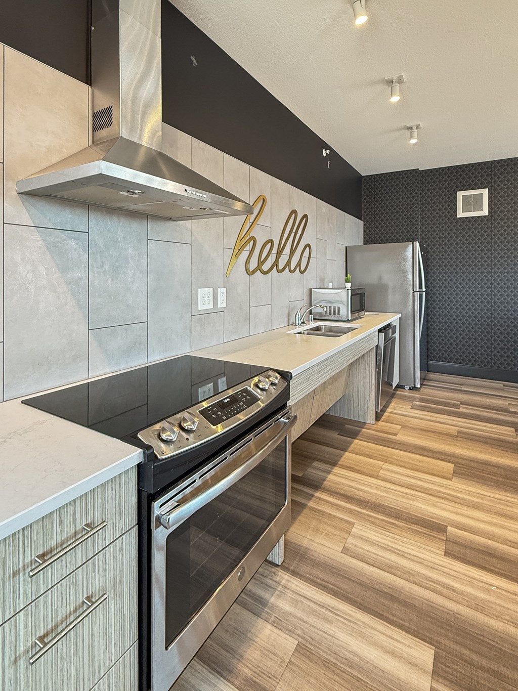 A modern kitchen with a stove top oven and a refrigerator.