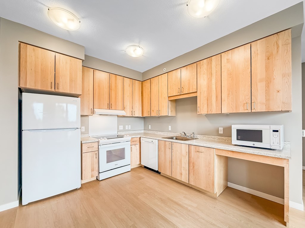 A kitchen with wooden cabinets and white appliances.