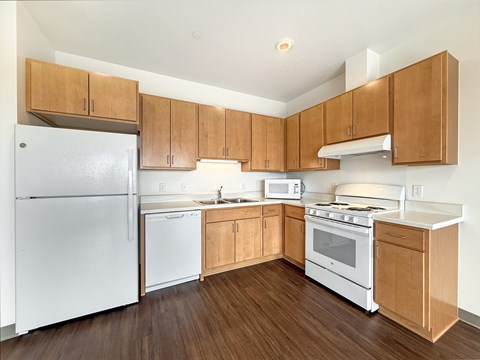 A kitchen with wooden cabinets and white appliances.