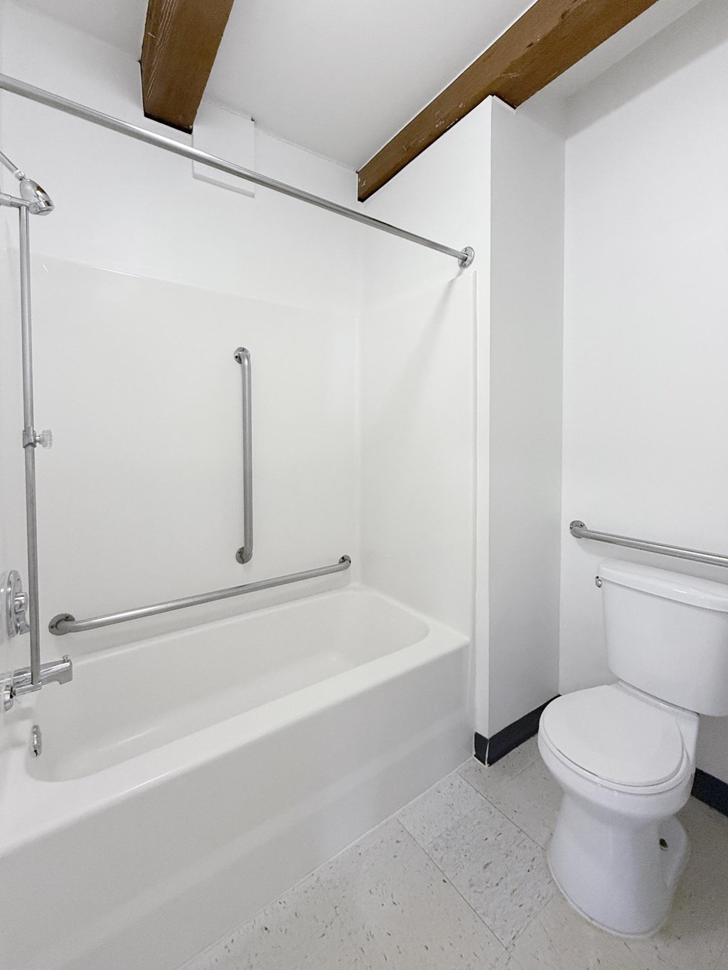 A white toilet sits next to a white bathtub in a bathroom.