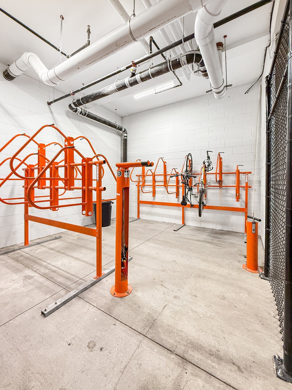 A gym with orange equipment and white walls.