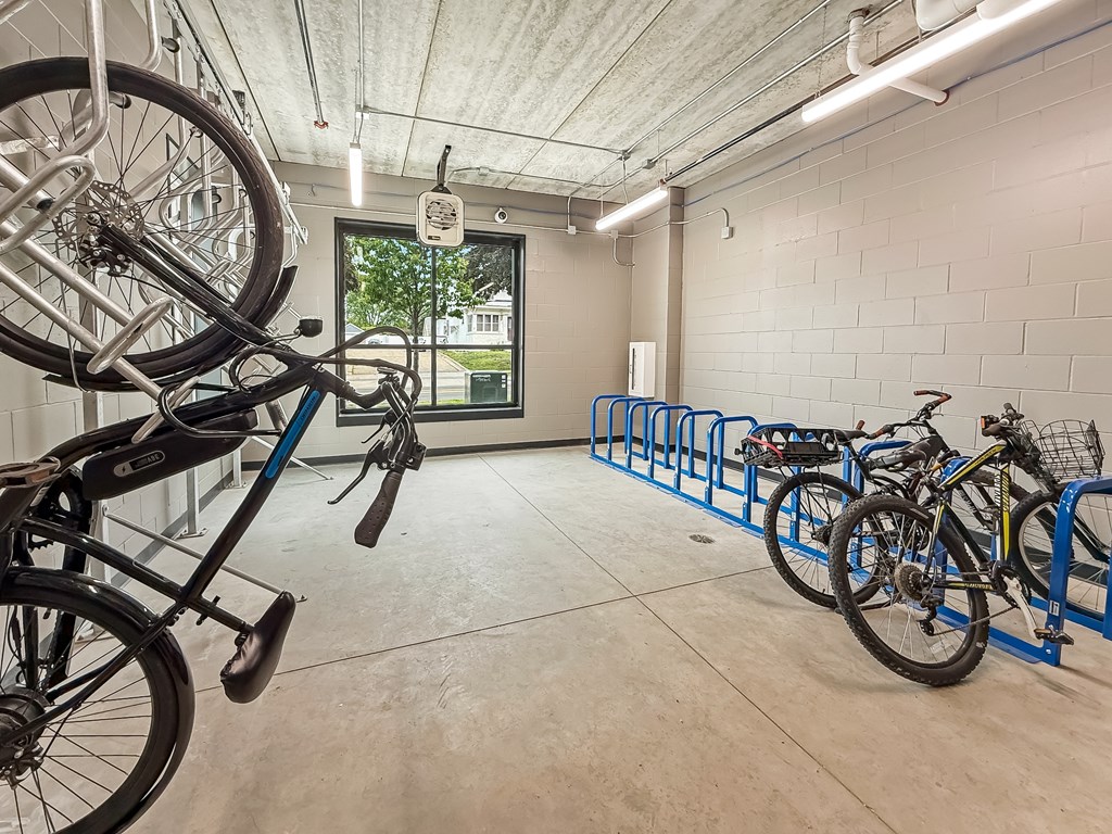A bike is parked on a blue bike rack in a white room.