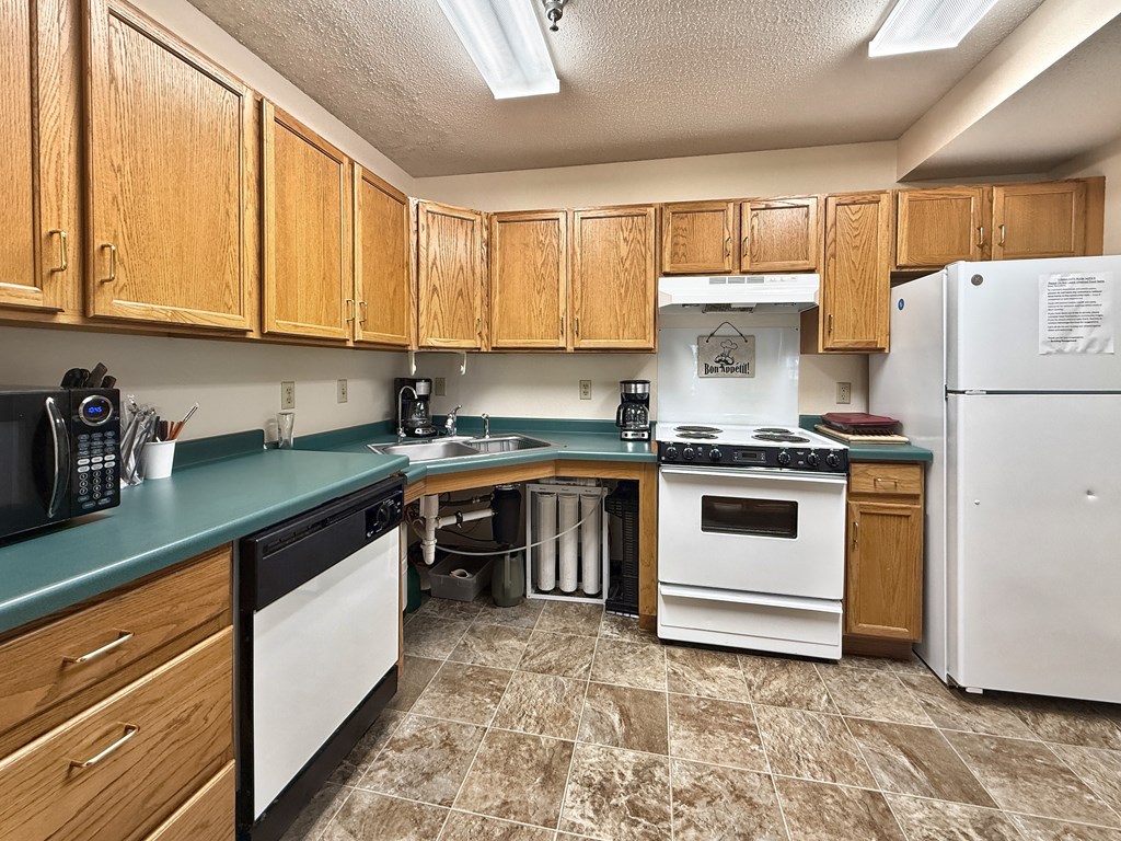 A kitchen with wooden cabinets and a white refrigerator.