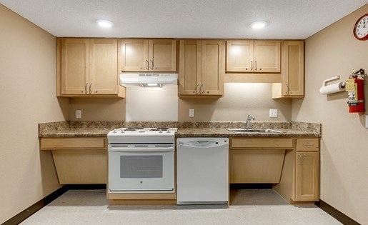 A kitchen with a white oven and dishwasher.