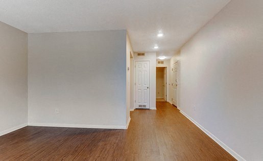 A long hallway with a white door at the end.