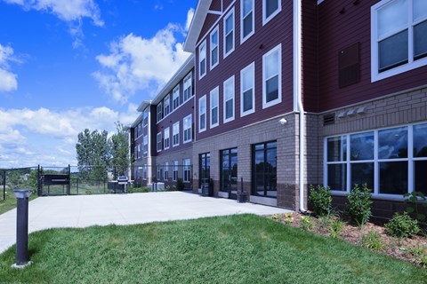 A red brick building with a white trim and a green lawn in front.