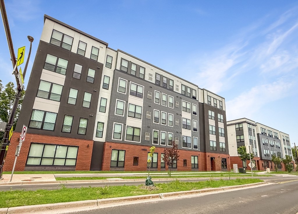 A modern multi-story building with a mix of dark and light-colored panels.
