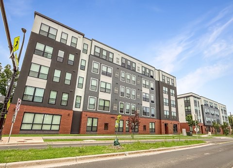 A modern multi-story building with a mix of dark and light-colored panels.