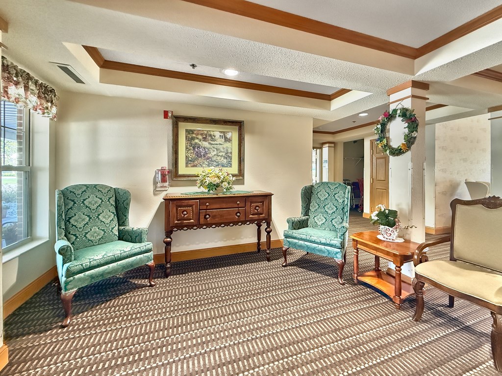 A room with a green chair and a wooden table.