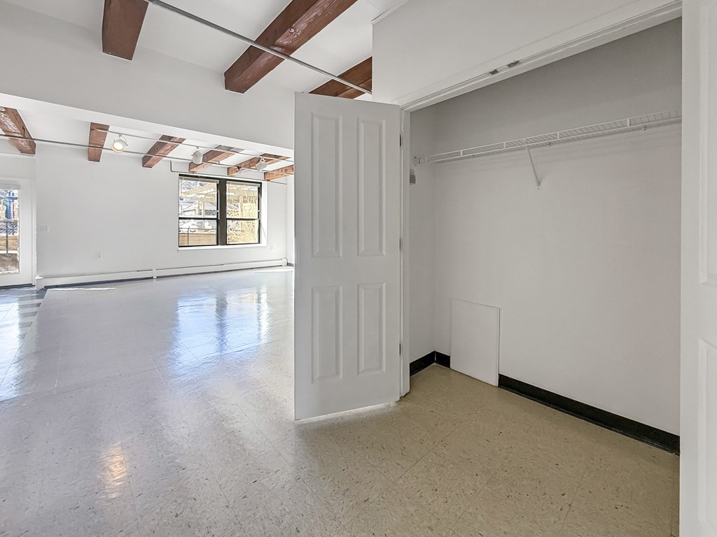 A large empty room with white walls and a window.