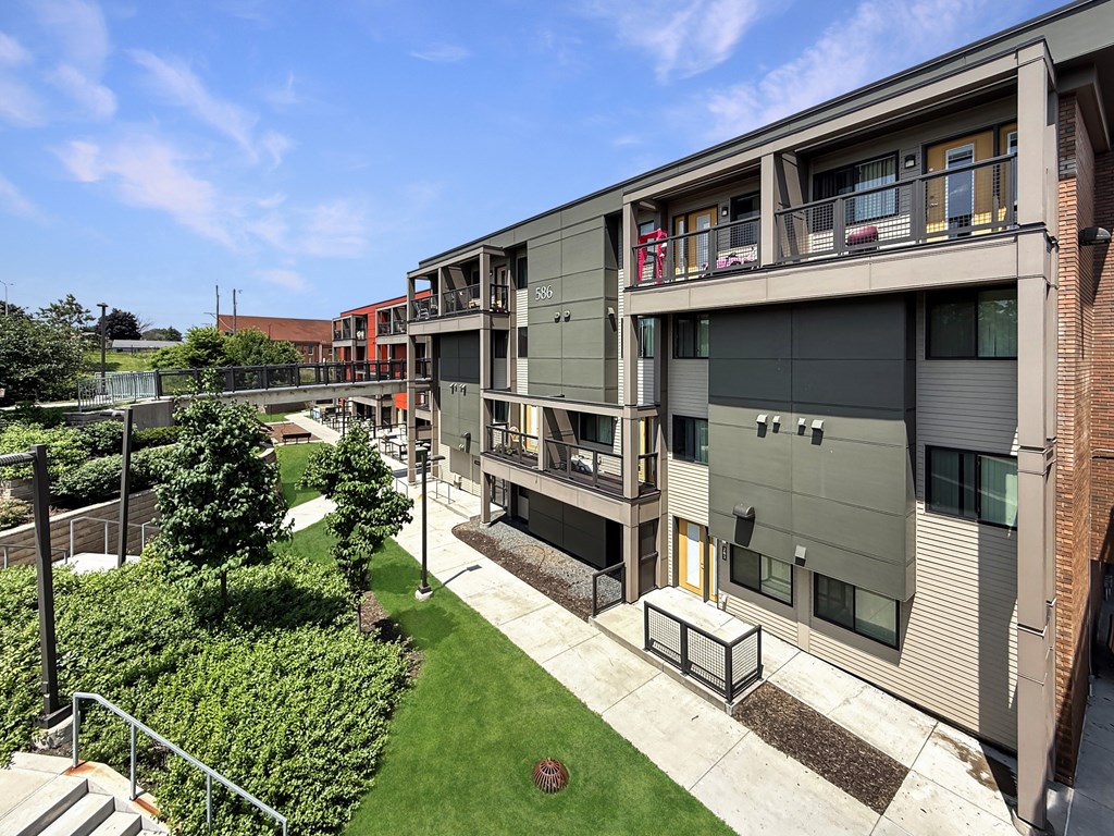 A modern apartment complex with a green lawn in front.