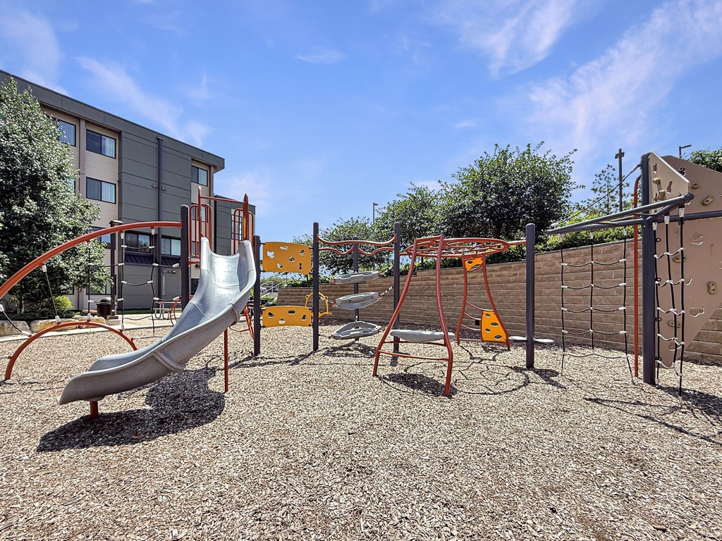 A playground with a slide, swings, and a climbing frame.